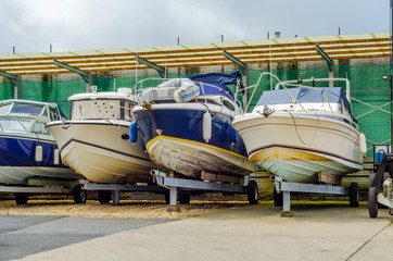 Boat on stand on the shore, close up on the part of the yacht, luxury ship, maintenance and parking...