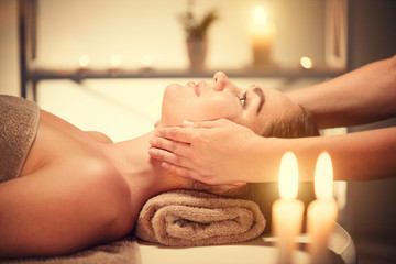Obraz na płótnie Canvas Spa facial massage. Brunette woman enjoying relaxing face massage in beauty spa salon