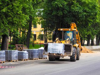 Tractor transports the packaging units. Road works. The improvement of the city.