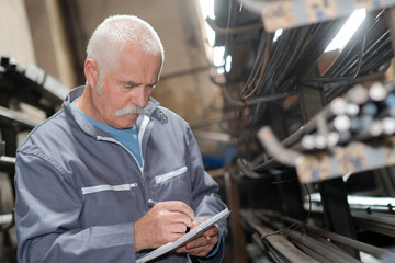 man with clipboard in safety vest at warehouse