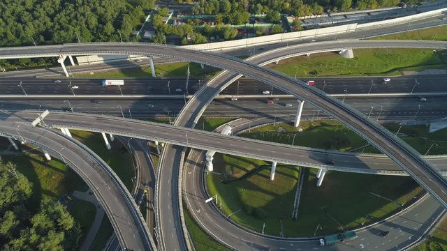 Multi-level road junction and cars traffic. Drone is flying to the right. Aerial vertical shot.