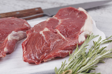 Raw fresh beef steak on a white cutting board