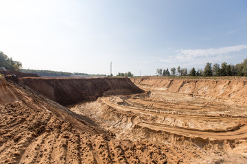 Mining in a sand quarry with powerful machines and a washing lake