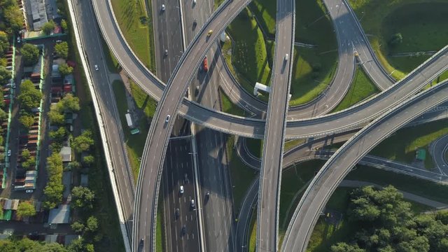 Multi-level road junction and cars traffic. Camera is tilting up. Aerial vertical shot.