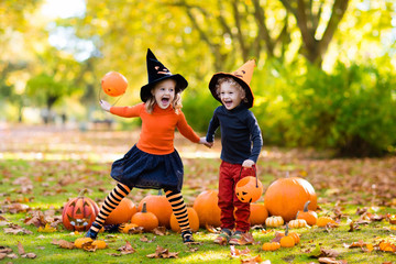 Naklejka premium Kids with pumpkins in Halloween costumes