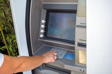 Young woman withdrawing money from credit card at ATM