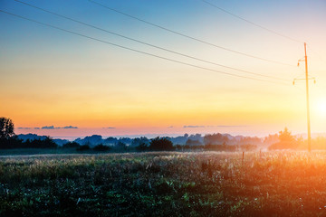 Beautiful dawn in the fog, nature and electric wire with a pillar