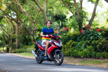 Teenager riding scooter. Boy on motorcycle.