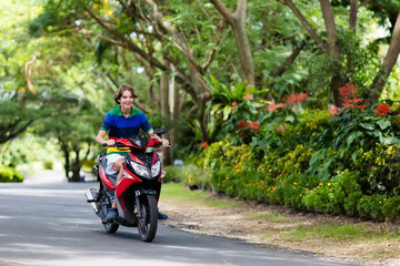 Teenager riding scooter. Boy on motorcycle.