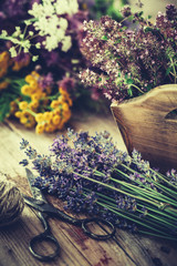 Bunch of lavender, thyme flowers in wooden box and healing herbs on background. Herbal medicine.