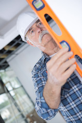 senior constructor holding a ruler