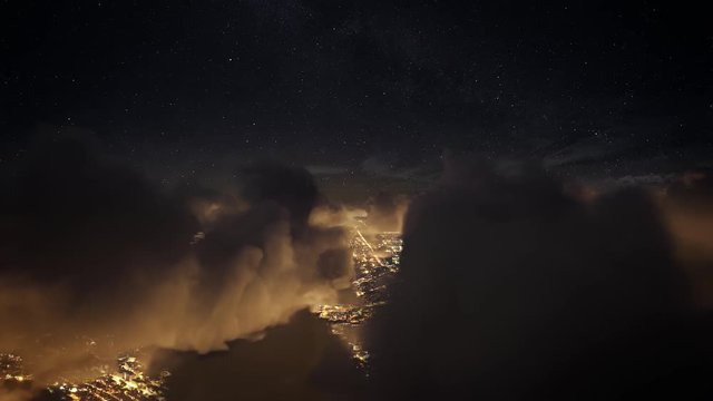 Flying over the deep night timelapse clouds with dark sky. Seamlessly looped animation. Flight through moving cloudscape over night city lights. Perfect for cinema, background, digital composition.
