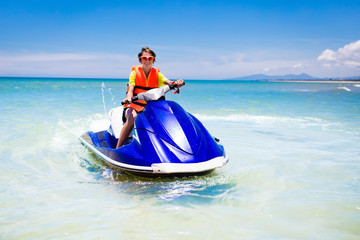 Teenager on water scooter. Teen age boy water skiing.