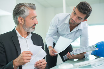 businessman and colleague writing on paper in the office