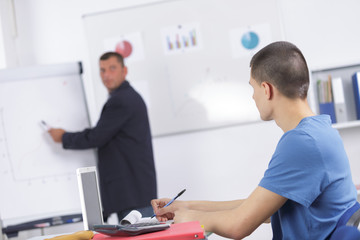 male teacher tutor near whiteboard screen giving lesson