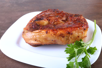 grilled pork chop with sauce on wooden table.