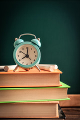 Alarm clock on stack of books