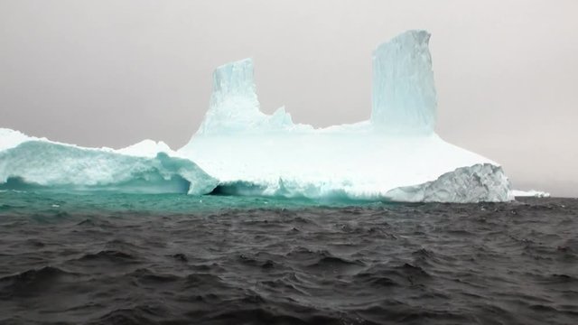 Huge unique glacier iceberg in ocean of Antarctica. Amazing beautiful wilderness nature and landscape of white mountains. Extreme tourism cold desert north pole.