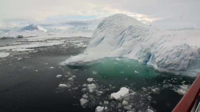 Ice movement and snow iceberg and glacier view from ship in ocean of Antarctica. Amazing unique beautiful wilderness nature and landscape of white mountains. Extreme tourism cold desert north pole.