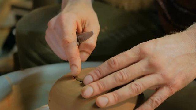 Professional male potter working in workshop, studio - making kettle. Close up shot of potter's hands. Handmade, small business, crafting work concept