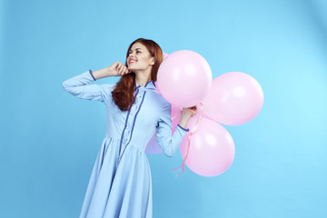 1398922 woman in blue dress holding pink balloons, holiday