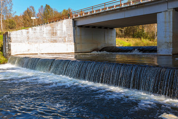 Waterfall on the river Suenga under a highway bridge. Siberia, Russia