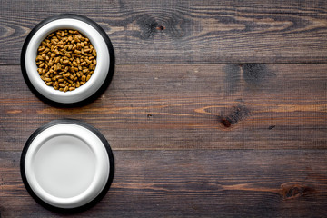 dry pet - cat food in bowl on wooden background top view mock up