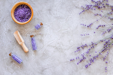 Fototapeta na wymiar home spa with lavender herbs cosmetic salt for bath on stone desk background top view mock-up