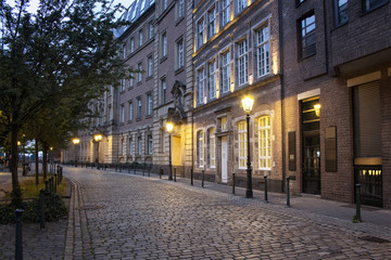 Evening view of old, historical buildings and cobblestone street in Altstadt Dusseldorf.
