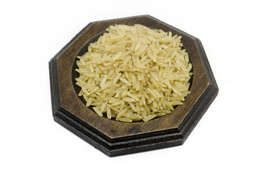 brown rice on wood plate on isolated white background