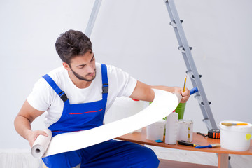 Repairman doing renovation repair in the house with paper wallpa