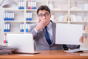 Fototapeta premium Businessman in office holding a blank message board