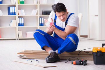 Young worker working on floor laminate tiles