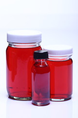 Red Liquid in Glass Bottle white cap