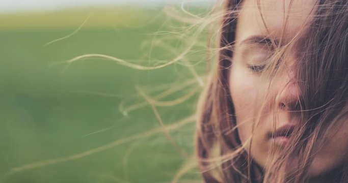 Close Up Portrait of Woman Standing on the Wind. SLOW MOTION 4K DCi. Breeze is playing with girls hair. Stormy weather, autumn, winter, spring. 