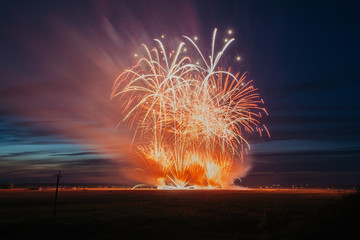 Fireworks over the city. Multi-colored fireworks against the background of the sunset sky.