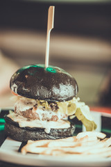 charcoal beef burger with French fries bread is black charcoal