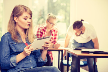 Student girl with tablet in front of her classmates