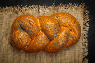 Wheat and bread on a black wooden background