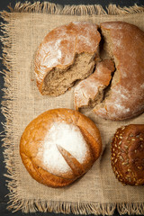 Composition of wheat and bread on a black wooden background