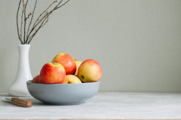 Ripe apples in a bowl on a white background. Autumn mood concept.