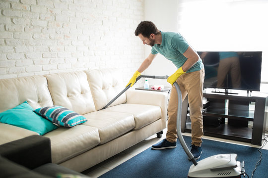 Latin man cleaning the sofa