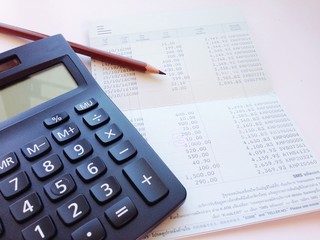 Business, finance, saving money, banking, loan, investment, taxes or accounting concept : Calculator, pencil and saving account book or financial statement on office desk table