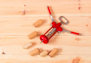 Corkscrew for wine and corks on wooden background