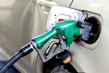 closeup car refueling on a petrol station white car with soft-focus and over light in the background