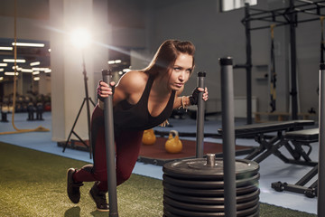 sled push woman pushing weights workout exercise