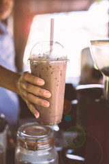 Coffee seller give ice chocolate with light flare.