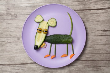 Funny mouse made of cucumber on plate and board