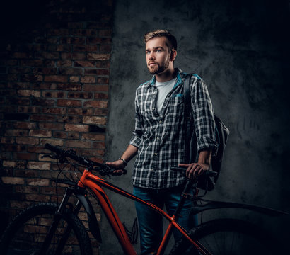 A mant holds red mountain bicycle.