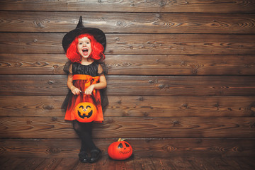 funny child girl in witch costume in halloween